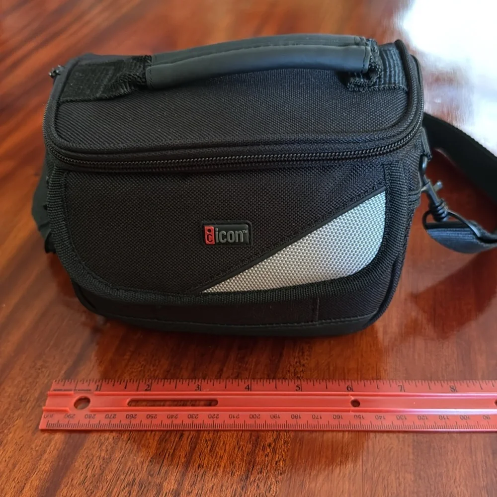 📷 Small iCon black camera bag with handle and shoulder strap.